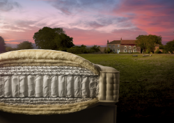 cut through detail of Harrison Spinks mattress showing internal layers set in a field at sunset