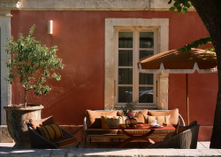 pink plaster, umbrella and couch outside villa augusta