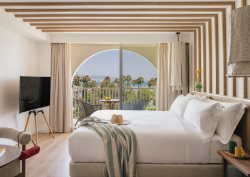 double bed in hotel guestroom ME Marbella with arched window and sea view