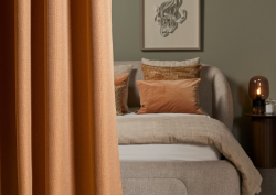 curtain draped in front of bed - Edmund Bell contract blackout fabric