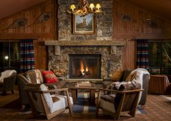 stone fireplace and wooden chairs in rustic Wayfinder hotel