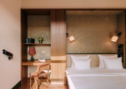 bed in guestroom at Chateau Royal berlin set in wooden back wall with shelf and light detail
