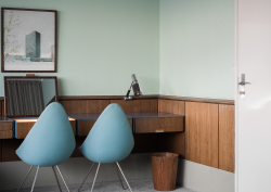 blue drop chairs by Arne Jacobsen in front of wooden desk in Radisson Collection Royal Hotel